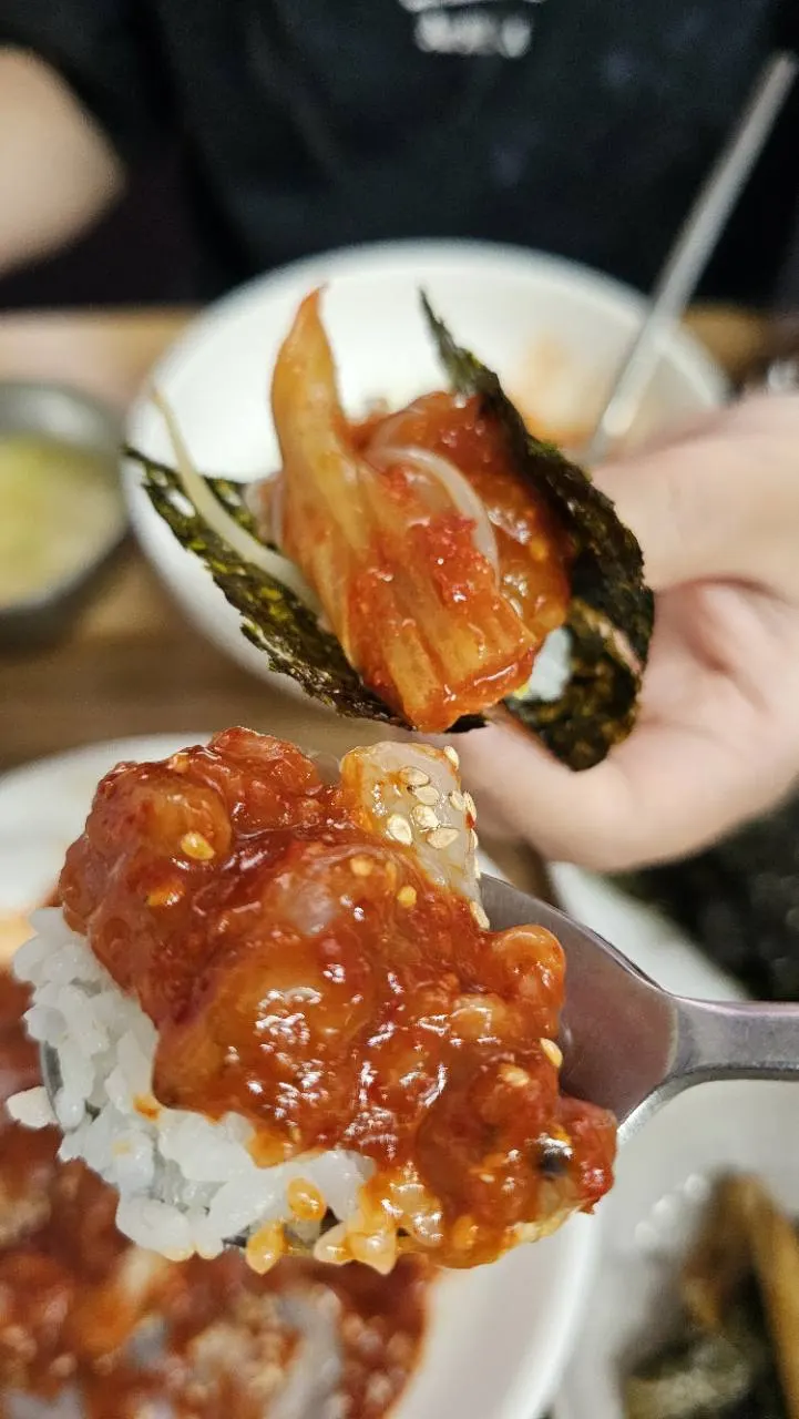 밥 위에 꽃게살을 올린 숟가락과 김에 싼 한입
