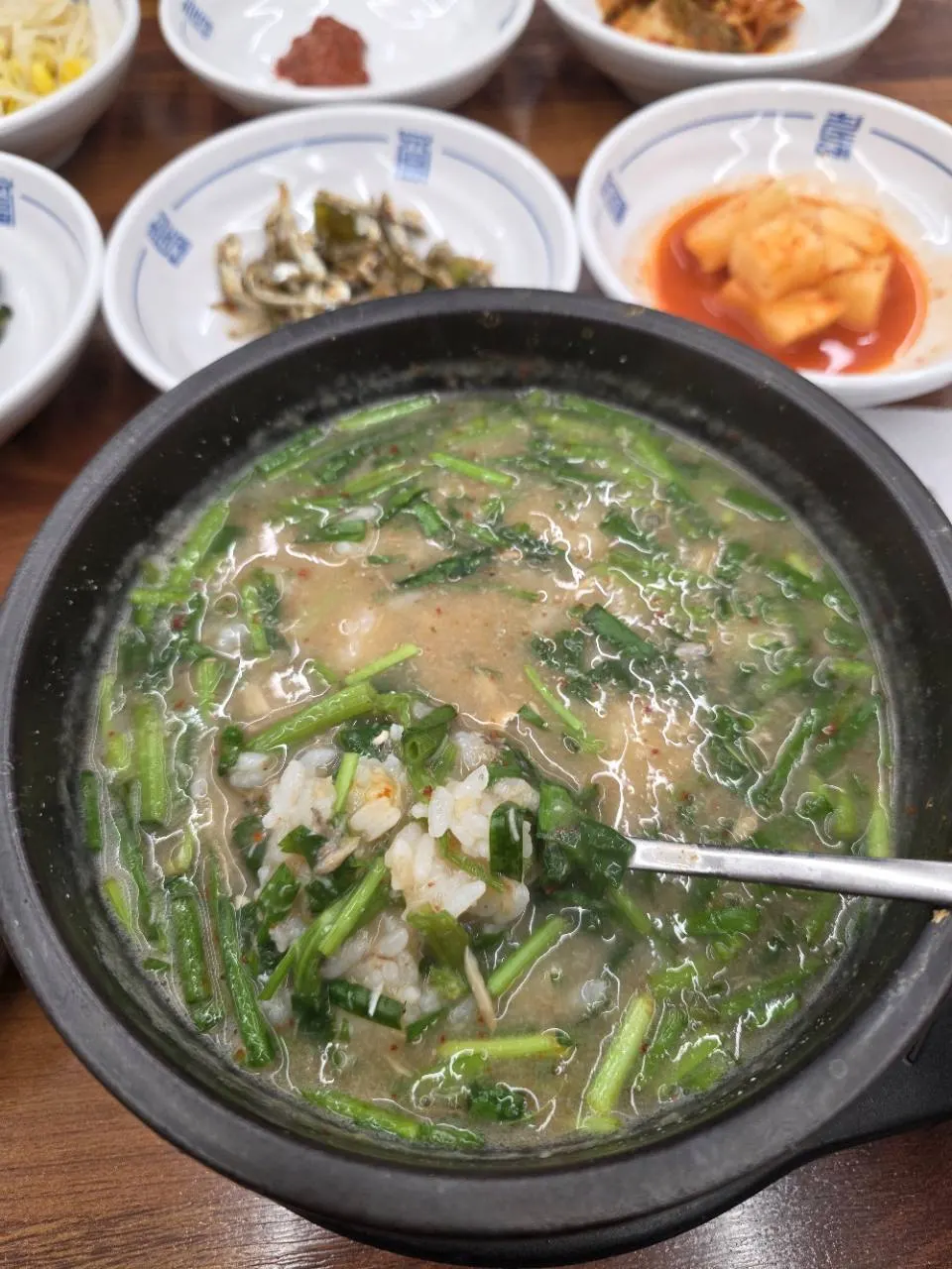 밥과 푸른 채소가 들어간 쫄복탕 국물 근접 사진